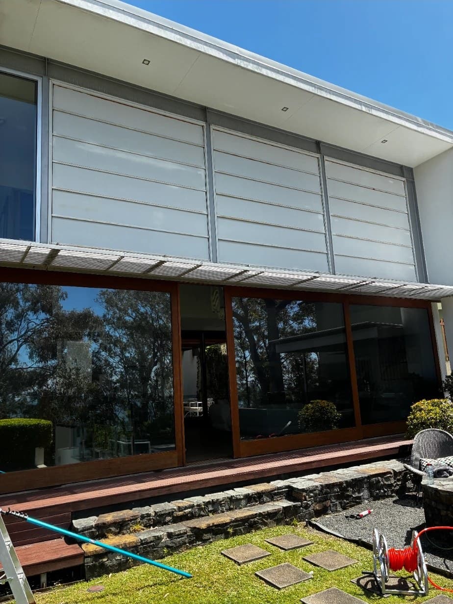 Squeegee Bros gear out on a real job: ladder, pole and hose reel behind a Brisbane home
